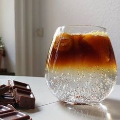 a glass filled with liquid next to a chocolate bar