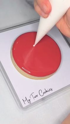 a person using a marker to write on a cookie