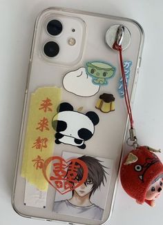 an iphone case with some stickers on it and a keychain next to it