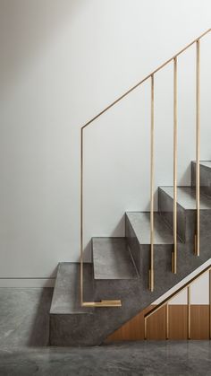 a set of stairs with metal railings and wooden handrails in an empty room