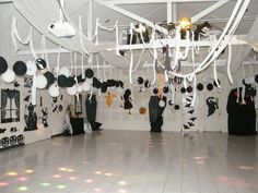 a room filled with black and white decorations on the walls, hanging from ceiling hooks