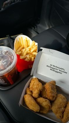 some food is sitting on a table in a car with fries and ketchup