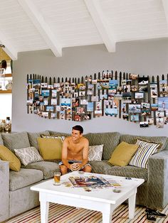 a man sitting on top of a couch next to a white coffee table