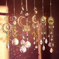 the sun, moon, and stars are hanging from chains with dangling drops of crystals