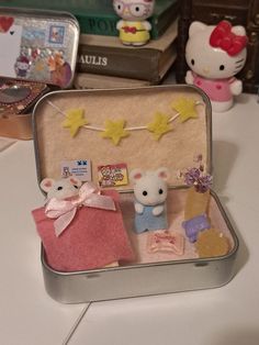 an open suitcase with two small stuffed animals in it on a table next to books