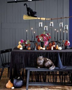 the table is set with candles, flowers and other items for halloween decorations on it