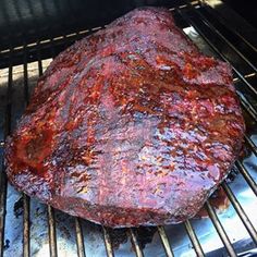 a large steak is cooking on the grill