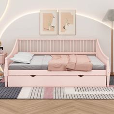 a pink daybed with drawers underneath it in a room that has hardwood floors and white walls