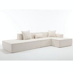 a large white couch with pillows on it's back and side facing the camera