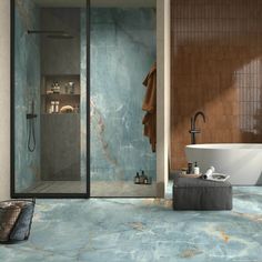 a bathroom with blue marble flooring and walls, along with a bathtub in the corner