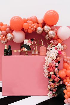 an orange and pink birthday party with balloons