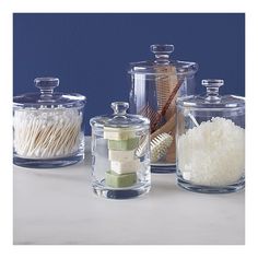 four glass containers with different types of items in them