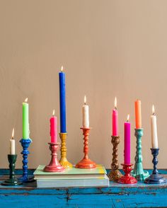 a table topped with candles and books on top of blue wooden tables covered in colorful cloths