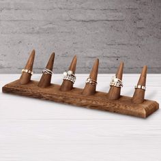 six rings are placed on top of a wooden ring holder with three different sizes and shapes