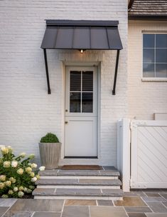 a white front door with a black awning