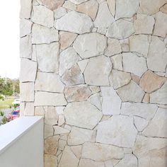 a white bench sitting in front of a stone wall