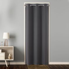 a gray shower curtain in a room with hardwood floors and white walls on the wall