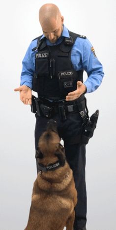 a police officer standing next to a dog