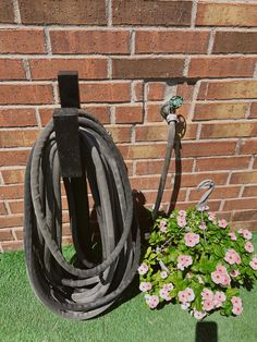 a garden hose next to a brick wall