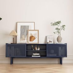 a living room with a blue sideboard and some pictures on the wall next to it