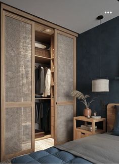 a bedroom with blue walls and an armoire in the corner, next to a bed