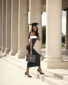 a woman in graduation cap and gown holding a briefcase