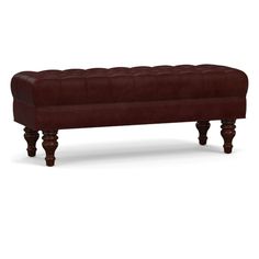 a brown leather bench with wooden legs and an upholstered foot rest on the bottom