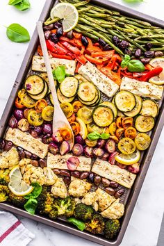 a tray filled with grilled vegetables and lemon wedges next to a text overlay that reads keto meal fresh greek vegetables, w / baked feta