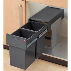 an open trash can sitting in the middle of a kitchen cabinet with two separate bins