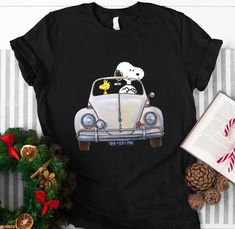 a snoopy car driving down the road with peanuts on it's hood shirt