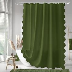 a green shower curtain with scalloped edges on a white bathroom floor next to a window