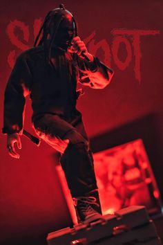 a man standing on top of a suitcase in front of a red background with the words toogo written across it