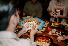 people sitting around a table with food and drinks