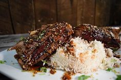 a white plate topped with meat and rice