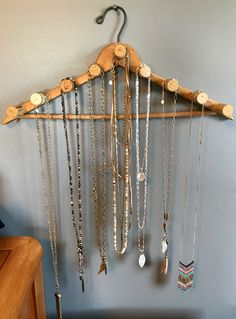 a wooden coat rack with many necklaces hanging from it