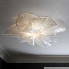 a ceiling light that is hanging from the ceiling in a room with white walls and black flooring