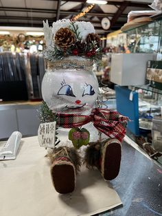 a snowman made out of glass sitting on top of a counter in a store