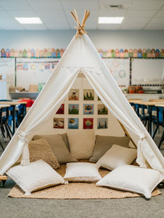 a teepee tent with pillows on the floor