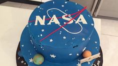 a blue cake with the nasa logo on it and some planets in space around it