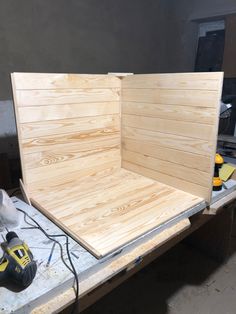 a wooden box sitting on top of a table next to a cordless driller