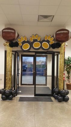 an entrance decorated with footballs and streamers