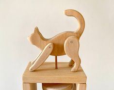 a wooden toy cat sitting on top of a stool