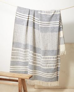 a blanket hanging on a clothes line next to a wooden bench