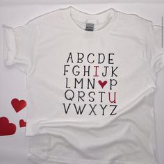 a white t - shirt with letters and hearts on it