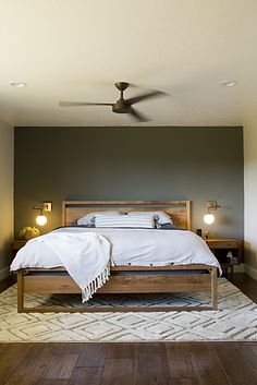 a large bed sitting on top of a wooden floor next to two tables and lamps