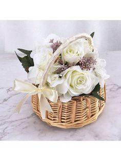 a basket filled with white flowers sitting on top of a marble counter next to a wall