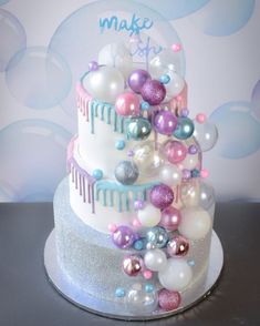 a three tiered cake decorated with balloons and confetti