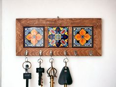 three key hooks are hanging on a wall with four different designs and colors in them