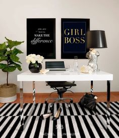 a black and white striped rug in front of a desk with two pictures on the wall