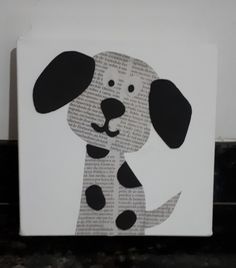 a black and white dog is sitting on a piece of paper that has been cut into the shape of a book page